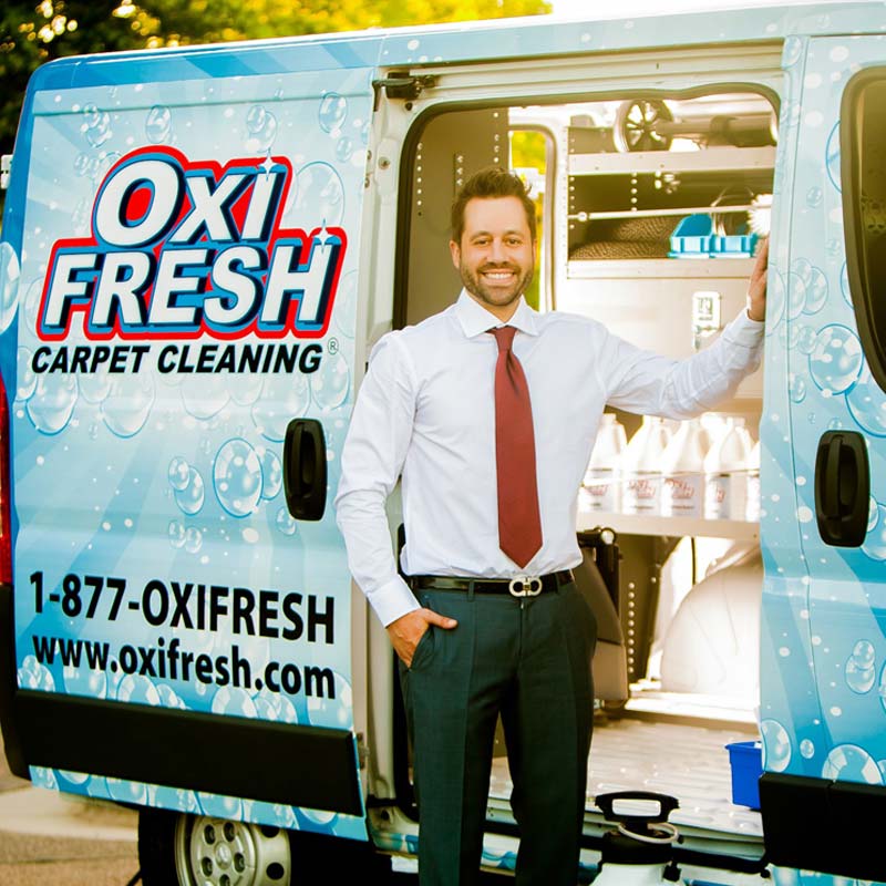 Jonathan Barnett, President and CEO of Oxi Fresh, standing in front of the carpet cleaning van