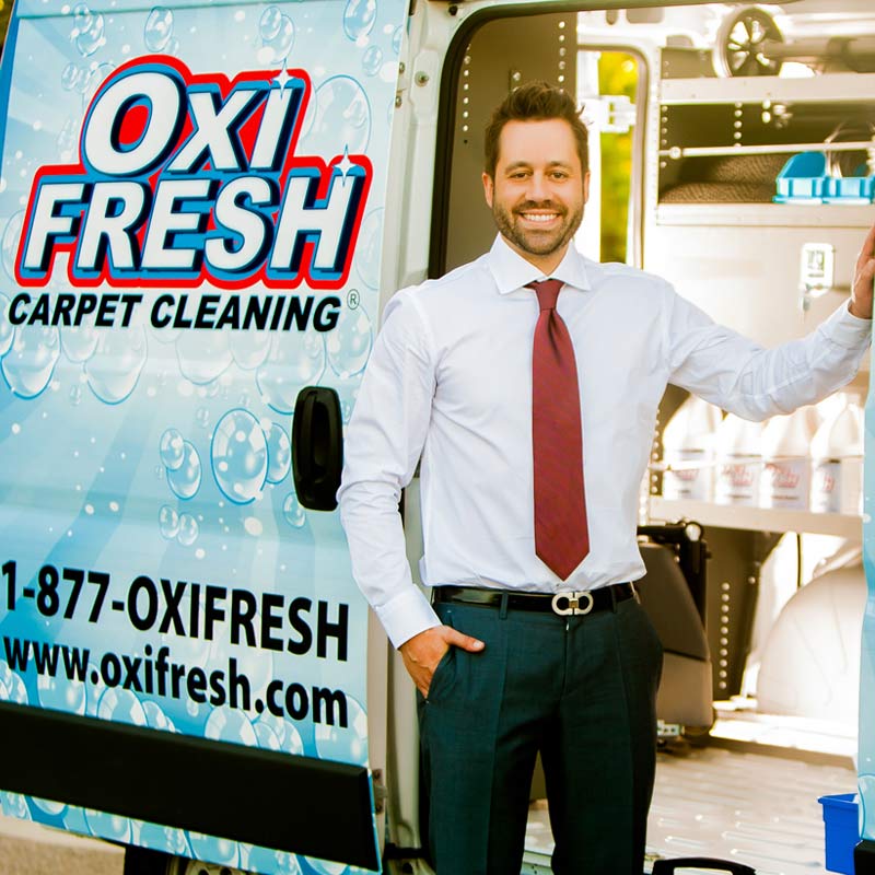 Jonathan Barnett standing in front of an Oxi Fresh vehicle with products inside the vehicle.
