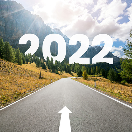 Road with an arrow pointing forward. The road runs into the mountains. The word "2022" in blocky white text floats in the background.