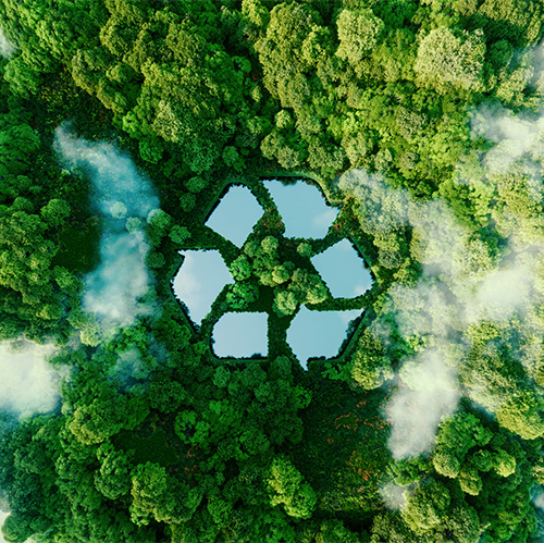 A top down shot of a lush, green forest with whisps of white clouds. In the center of the image is a photoshopped series of ponds designed to look like the traditional "Recycling Arrow"